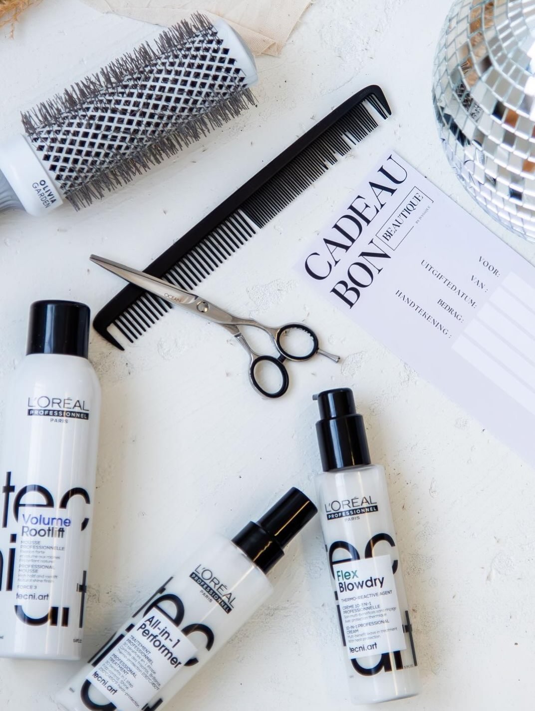 Cadeaubon van Beautique tussen een schaar, kam, borstel en stylingproducten van L'Oréal Professionnel